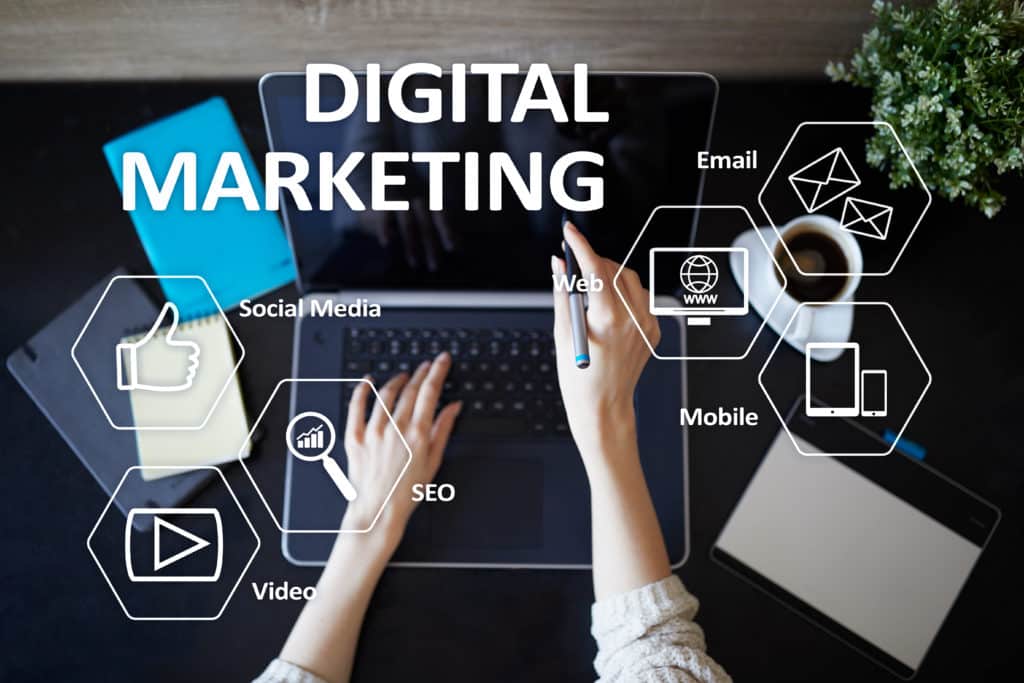 Someone working at a laptop with a digital marketing diagram as an overlay