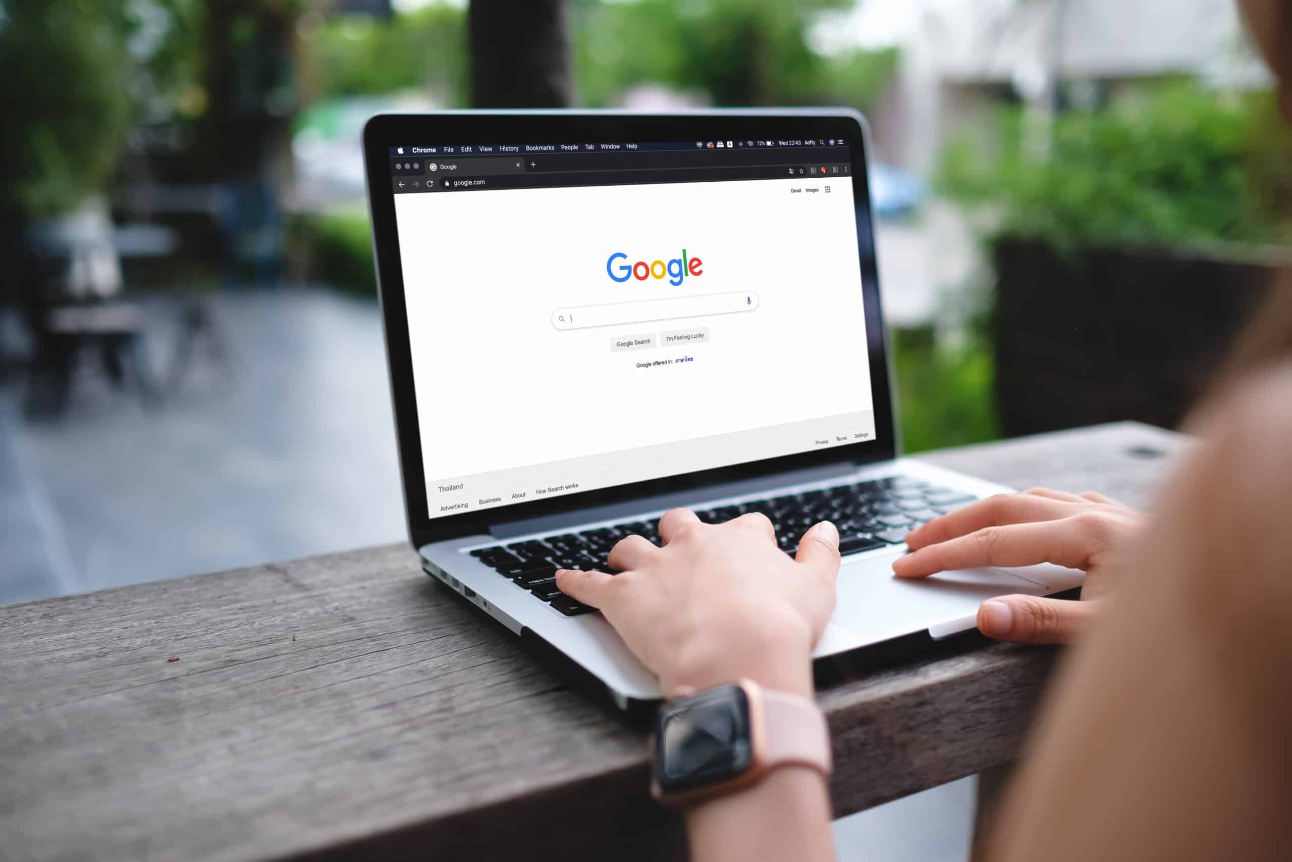 A woman is typing on Google search engine from a laptop. Google is the biggest Internet search engine in the world.