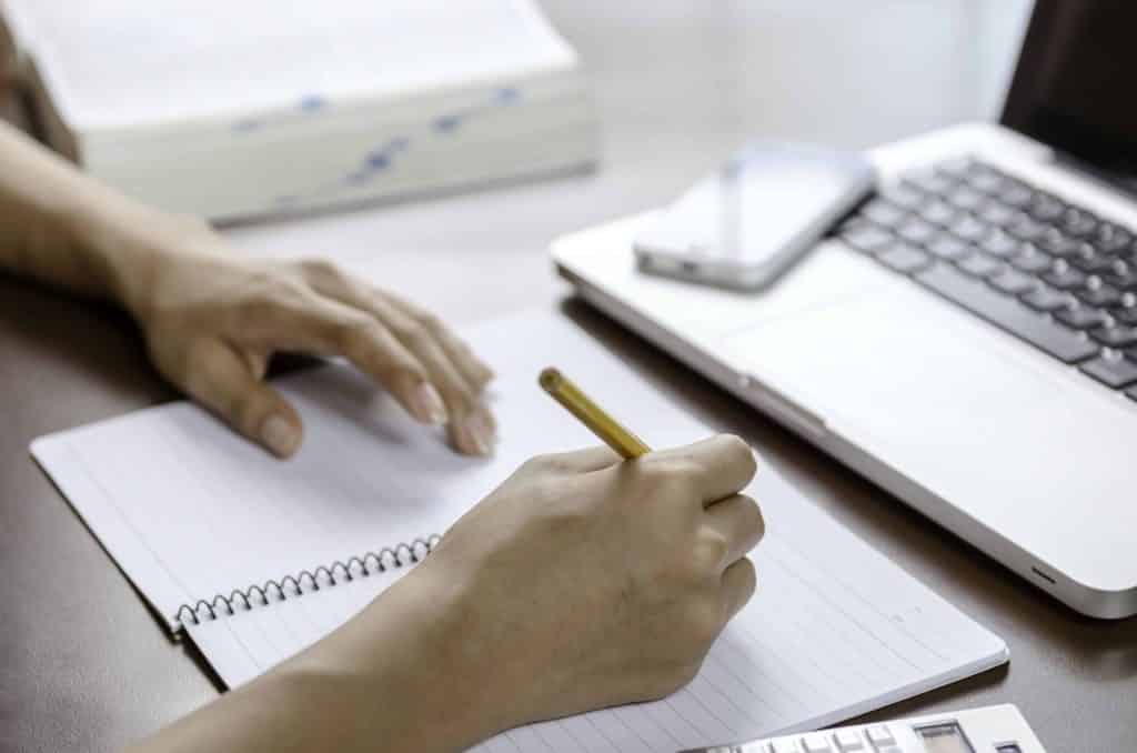 Someone brainstorming for content planning in a lined notebook