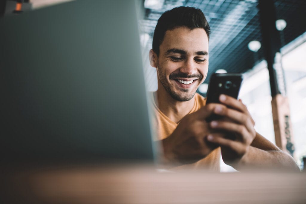 SEO Meta Tags can help reach people like this smiling young Millennial man on his phone